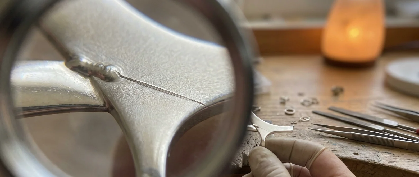A fine line running out of a nickel white gold weld into sound metal, seen under magnification