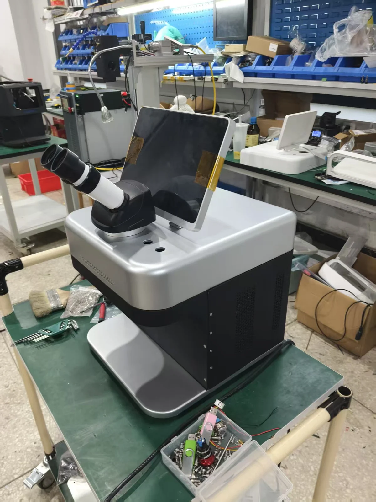 Jewelry repair equipment standing on a workshop bench with hand tools within reach